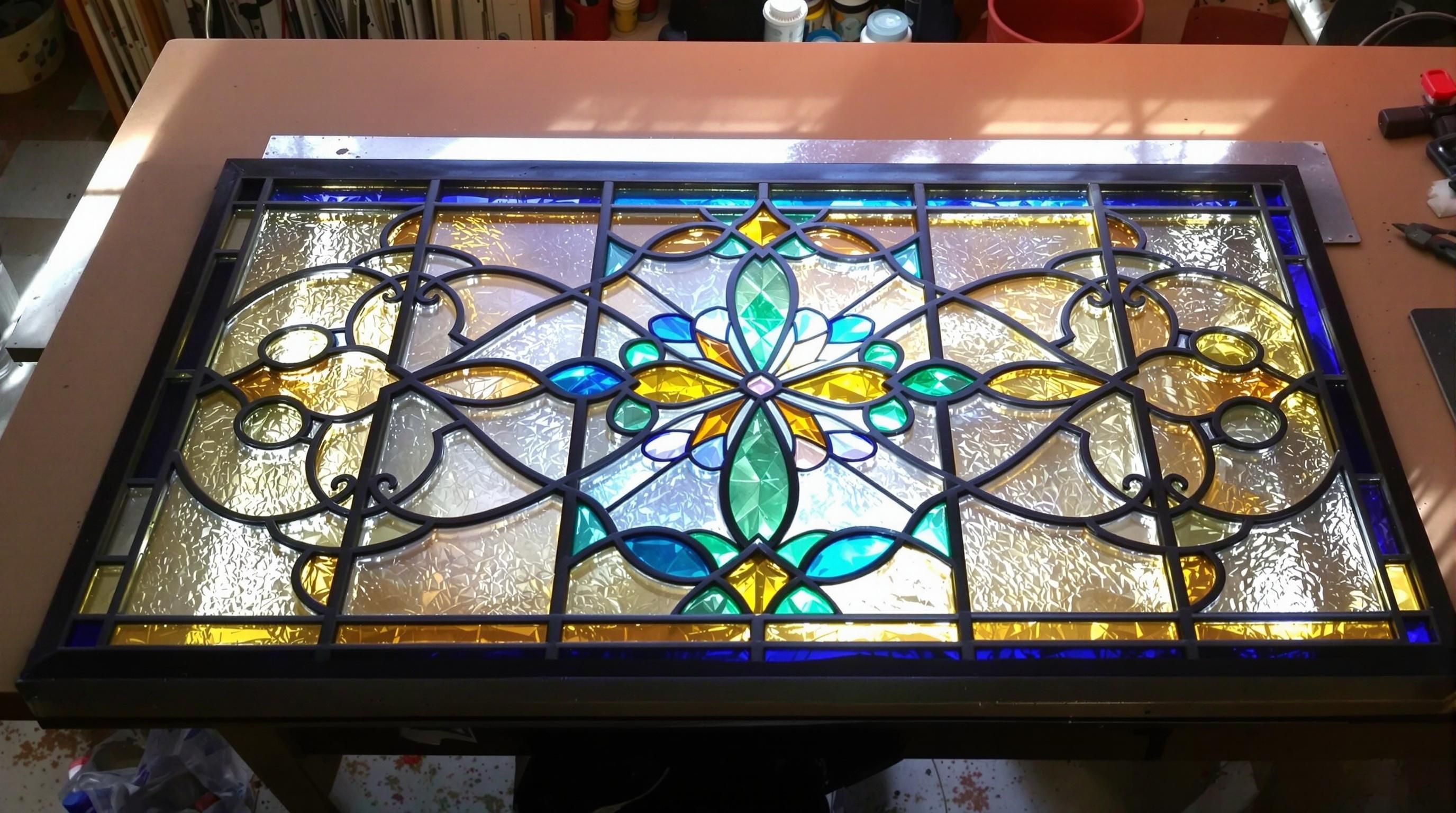 Stained glass window with intricate beveled glass elements and jewel inserts