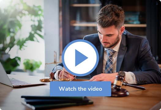 A lawyer writing at his desk behind a play button that says watch the video