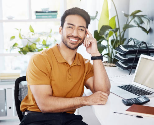 Relaxed accountant sitting at his desk after busy tax season using appointment management software.