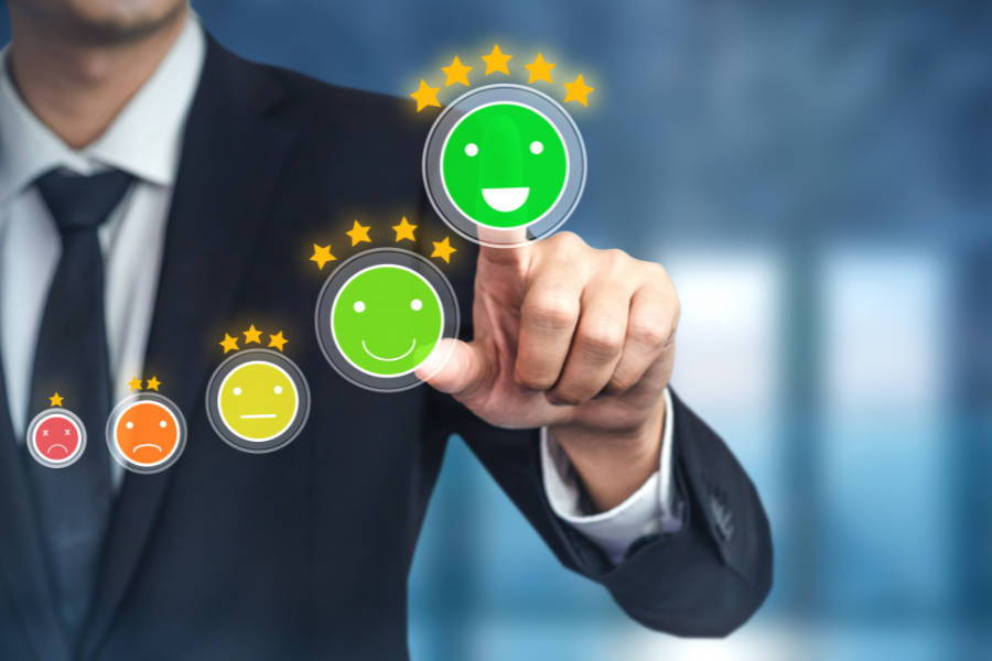 Businessman clicking happy face emoji to indicate 5-star review