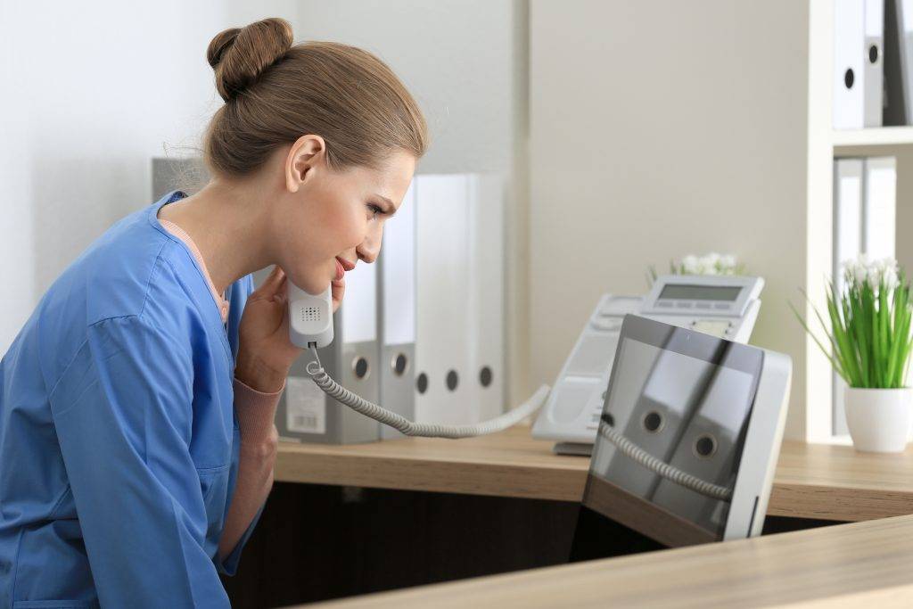 Nurse or administrative staff completing reminder call to patient.