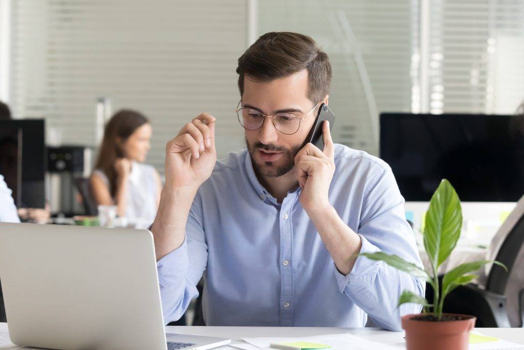 Man making call manually to remind client about upcoming appointment.