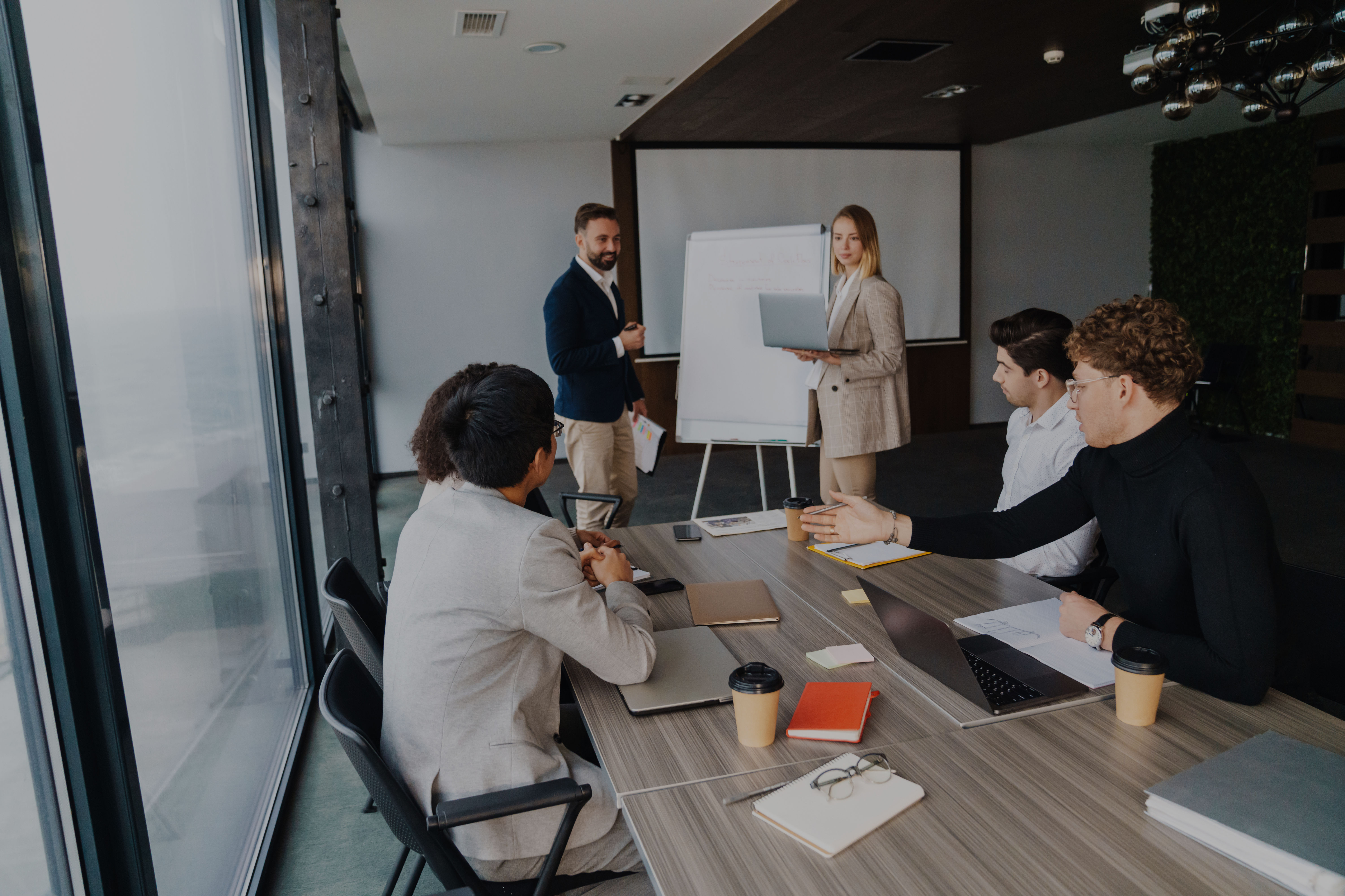 A group of professionals in a modern conference room are engaged in a meeting
