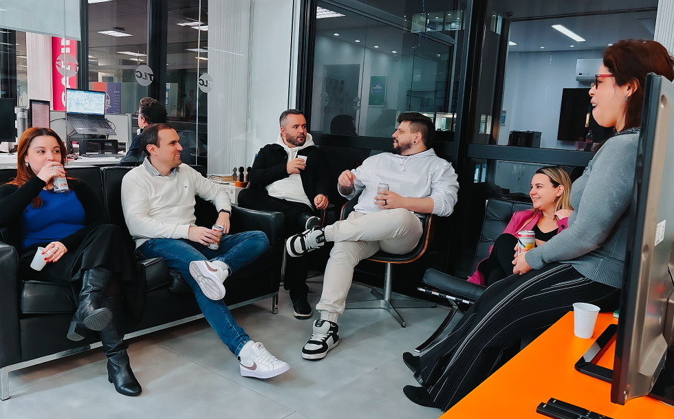 Four people sitting on couches and chairs, talking amongst themselves