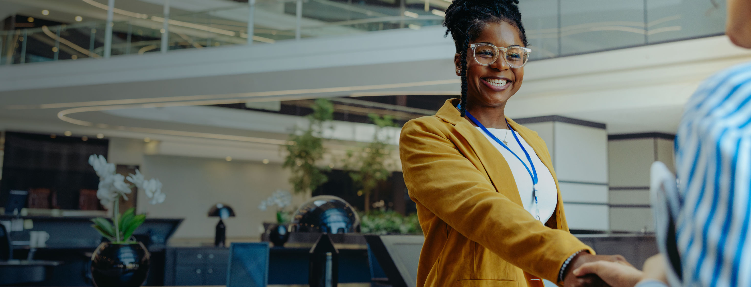 A smiling woman shaking hands with someone off-camera