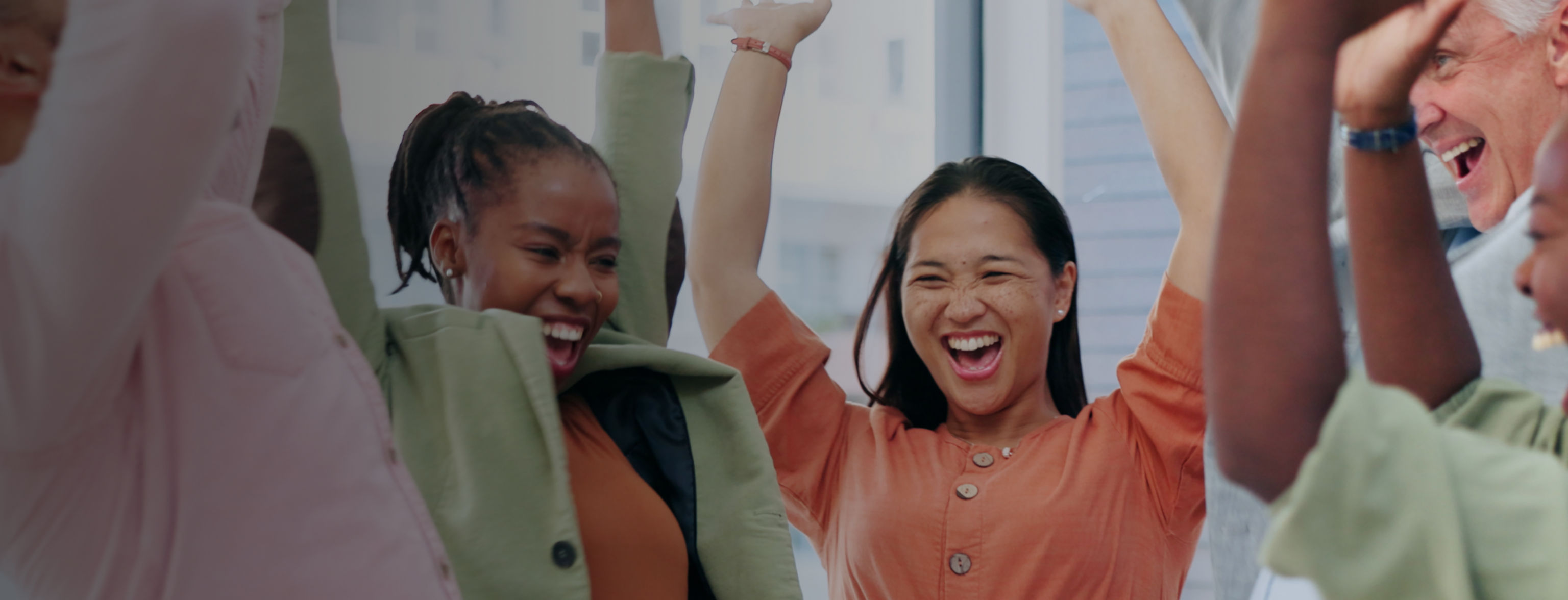 Five people celebrating with their hands in the air
