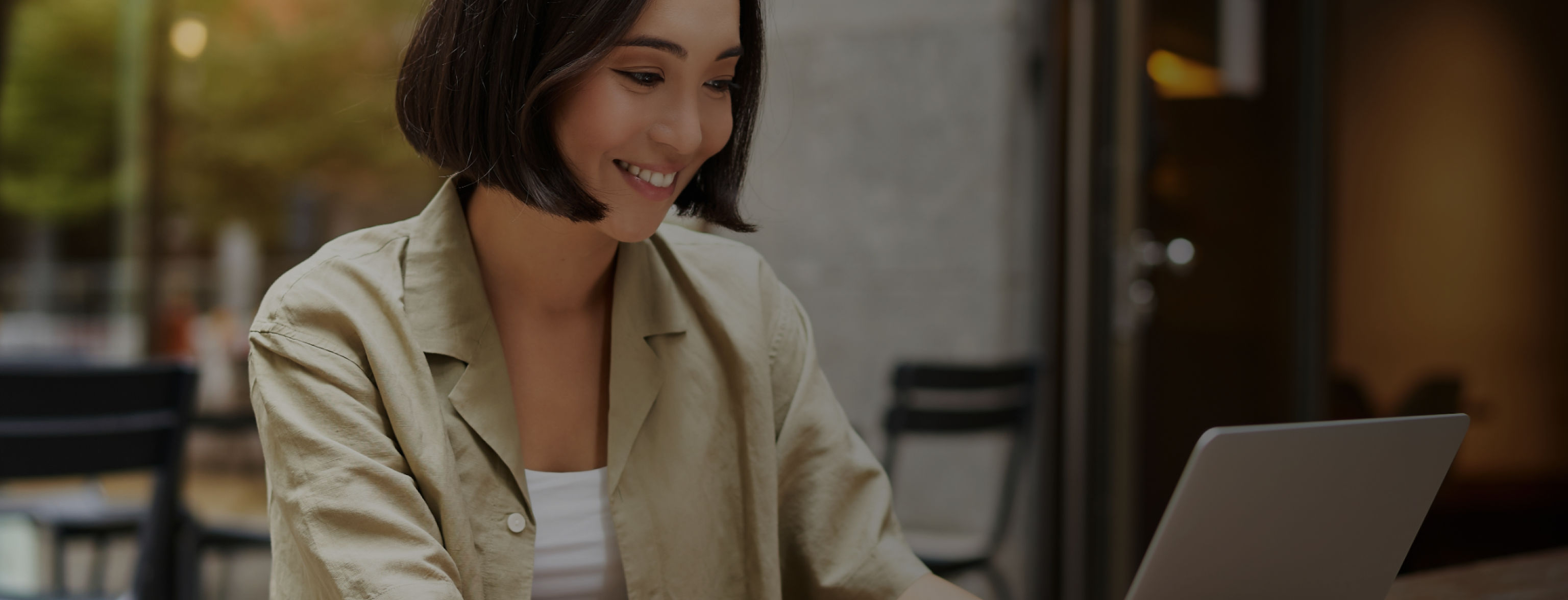 A woman looking at a laptop and smiling