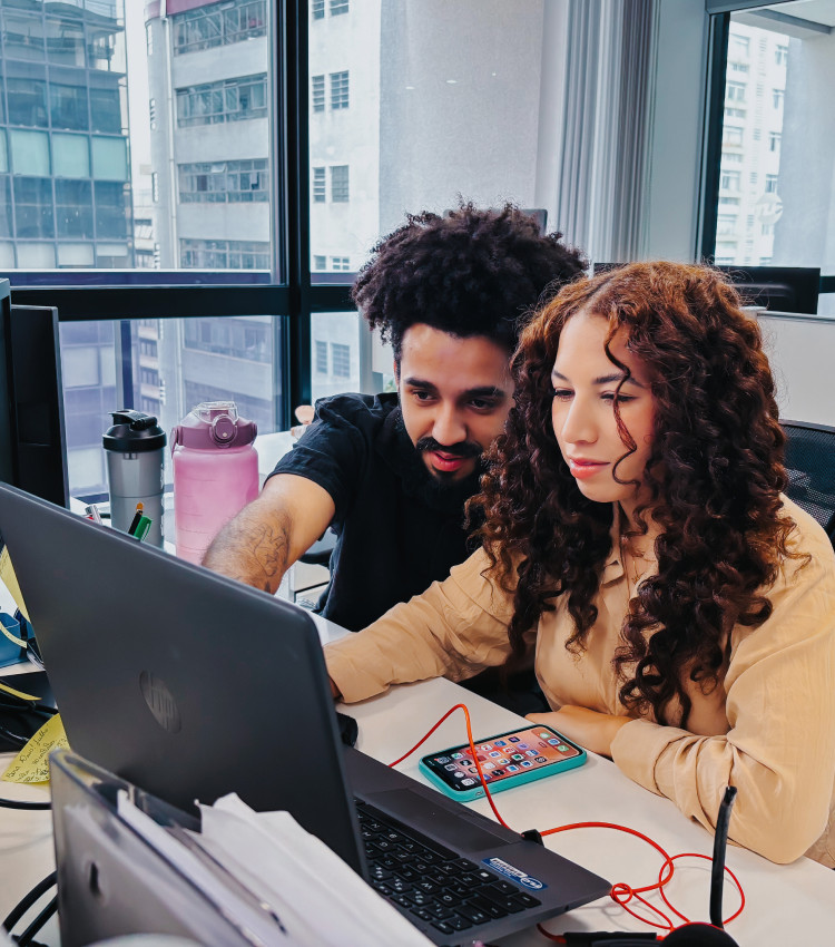 A man and a woman looking at a laptop screen, pointing at the screen