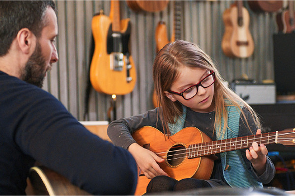 A girl learning to play guitar