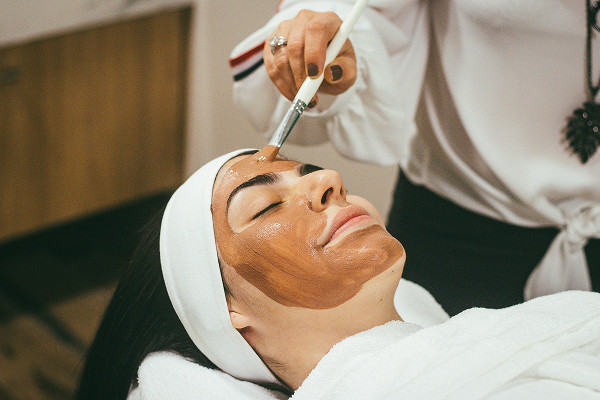 A woman lying down getting a spa facial treatment