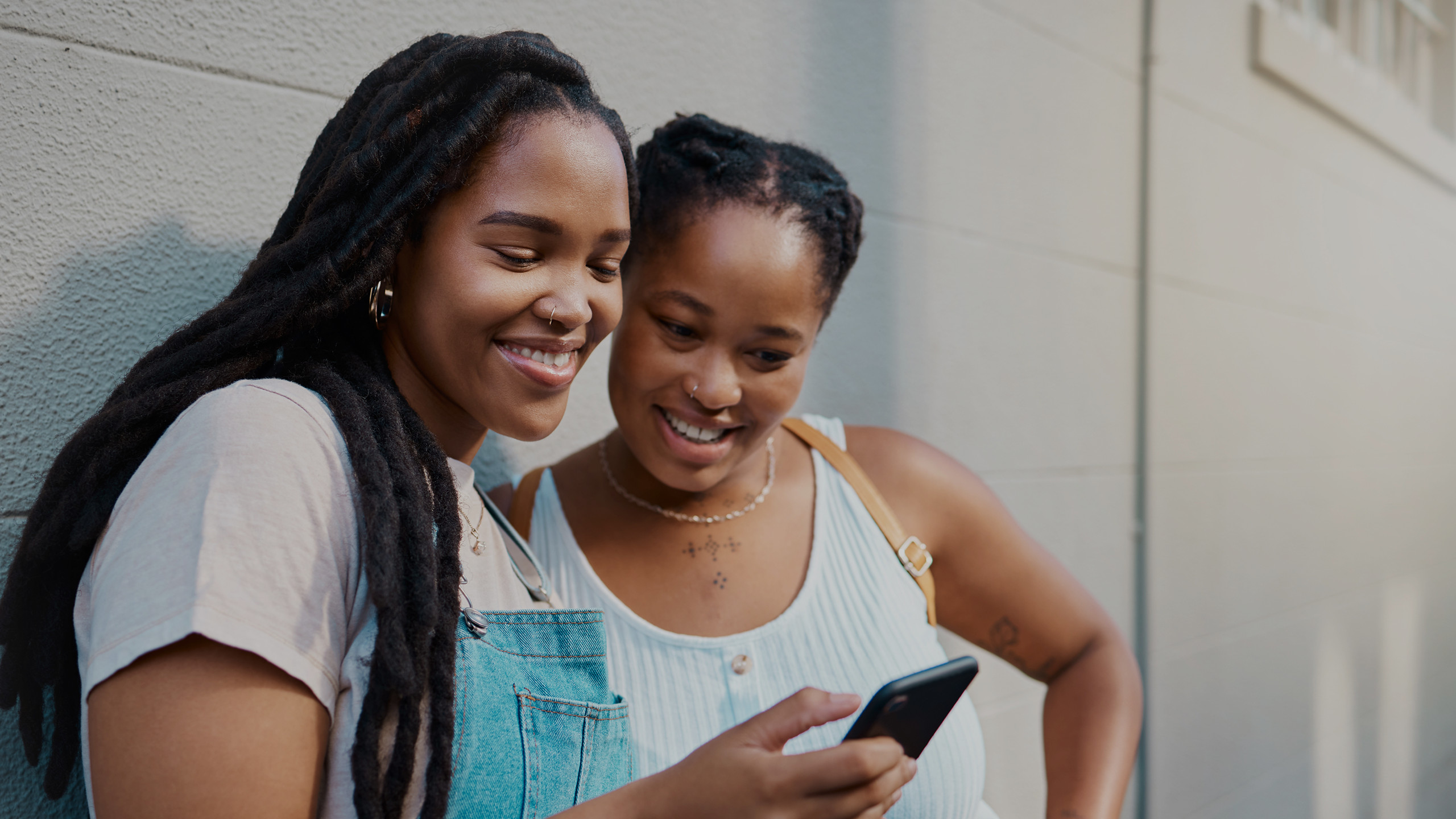 Two women looking and smiling at a mobile phone