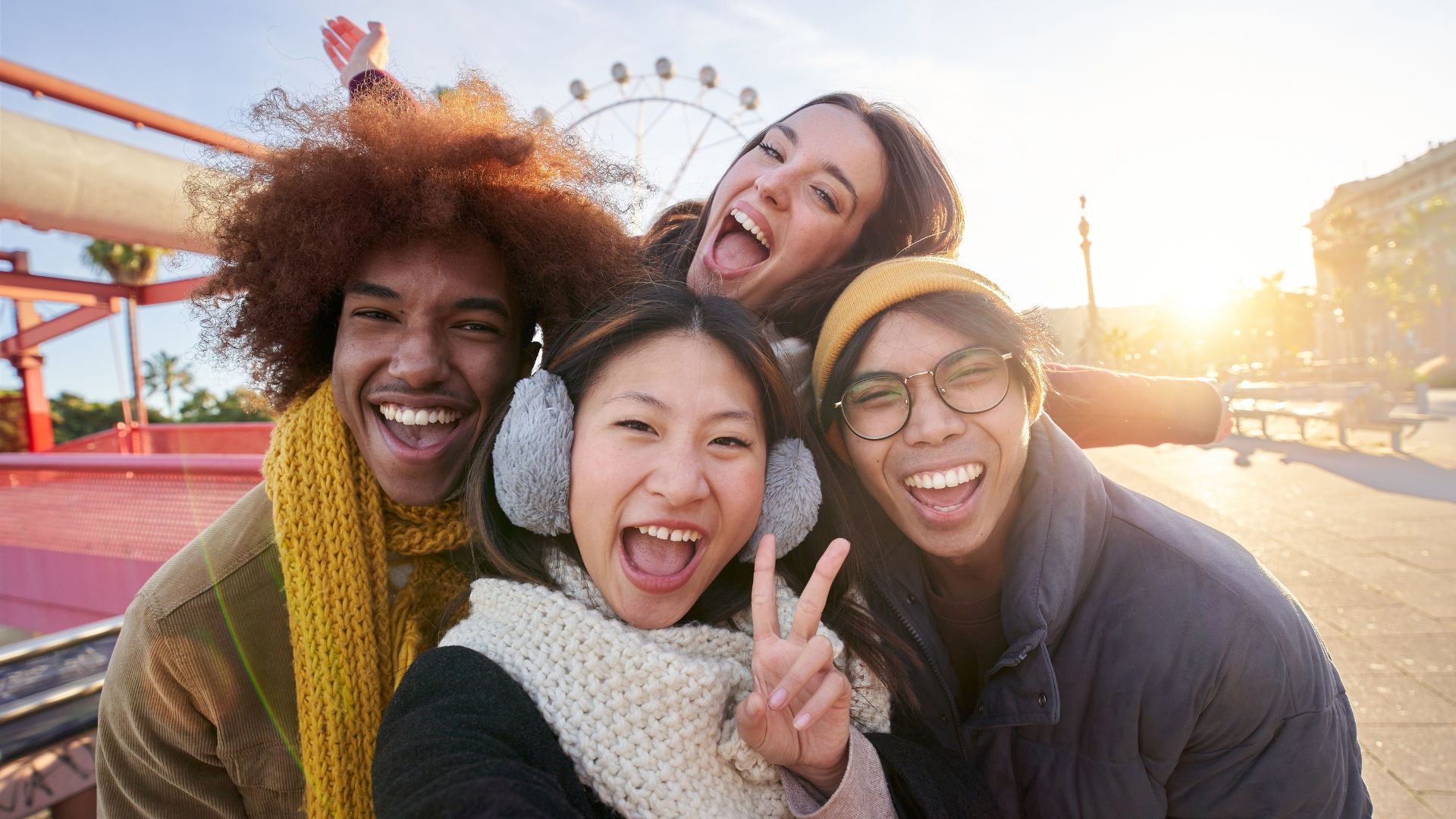A group of four friends posing for a selfie, all smiling