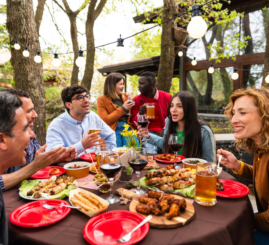 A group of friends enjoying a meal together at a restaurant, smiling and sharing food.