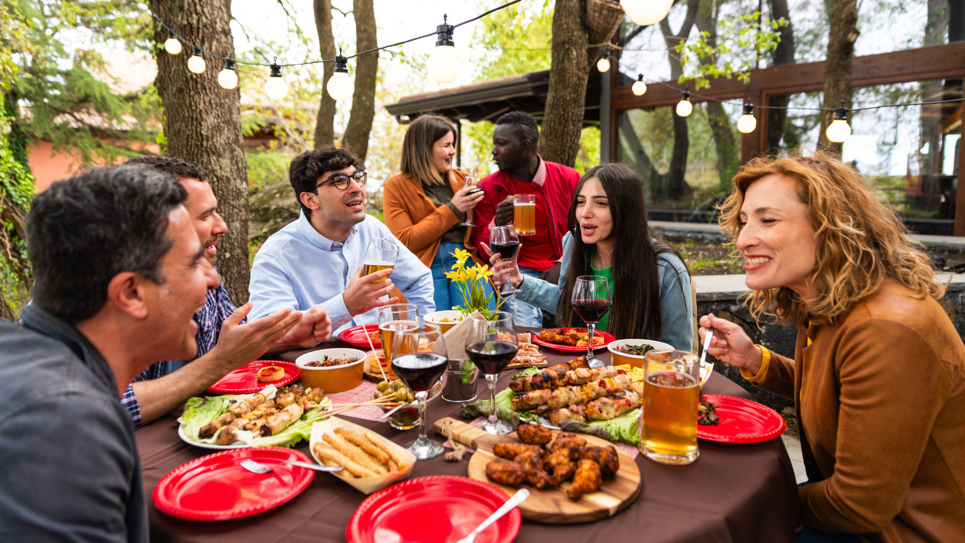 A group of friends enjoying a meal together at a restaurant, smiling and sharing food.