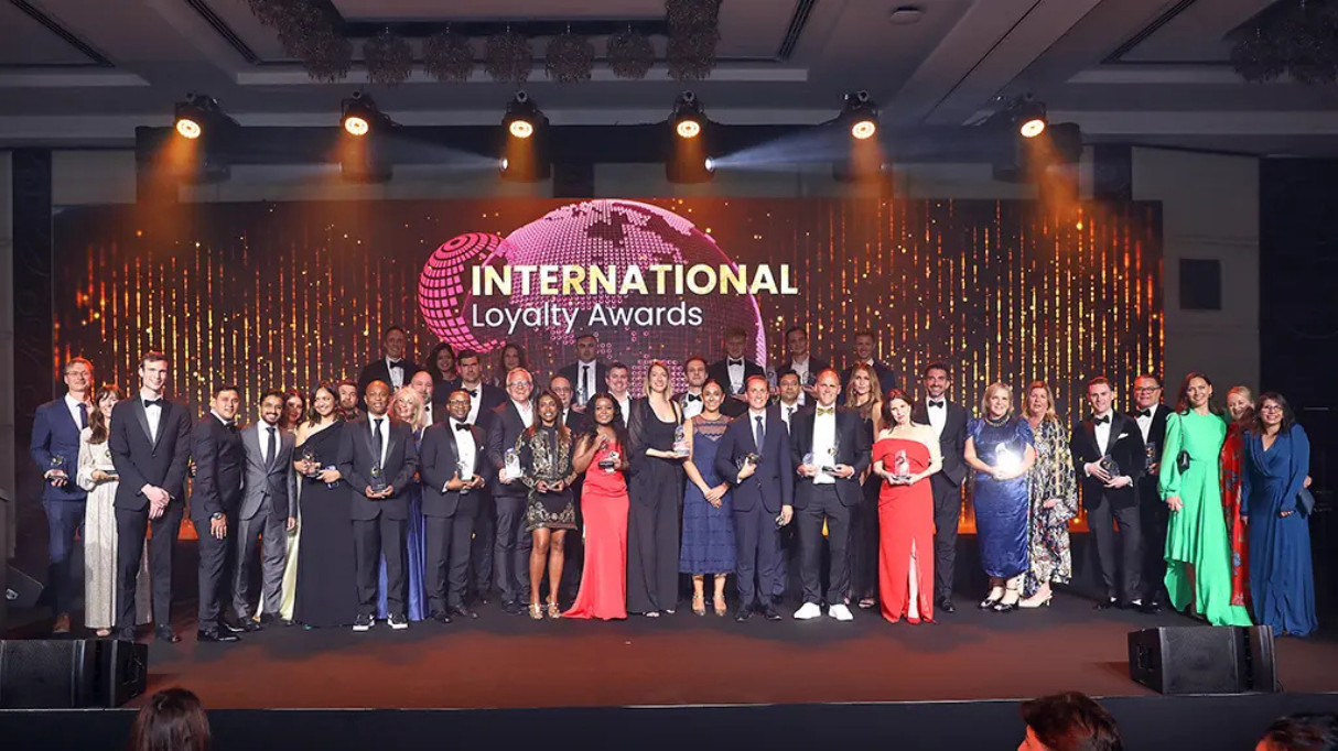 A group of people posing together on stage at the International Loyalty Awards event
