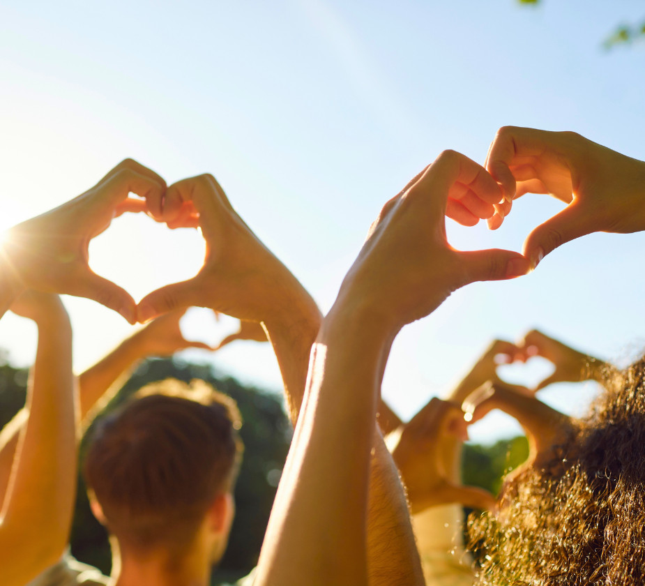 A group of people raising their hands to form heart shapes