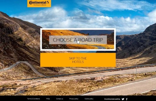 A scenic road winding through mountainous terrain under a blue sky, with the text "CHOOSE A ROAD TRIP
