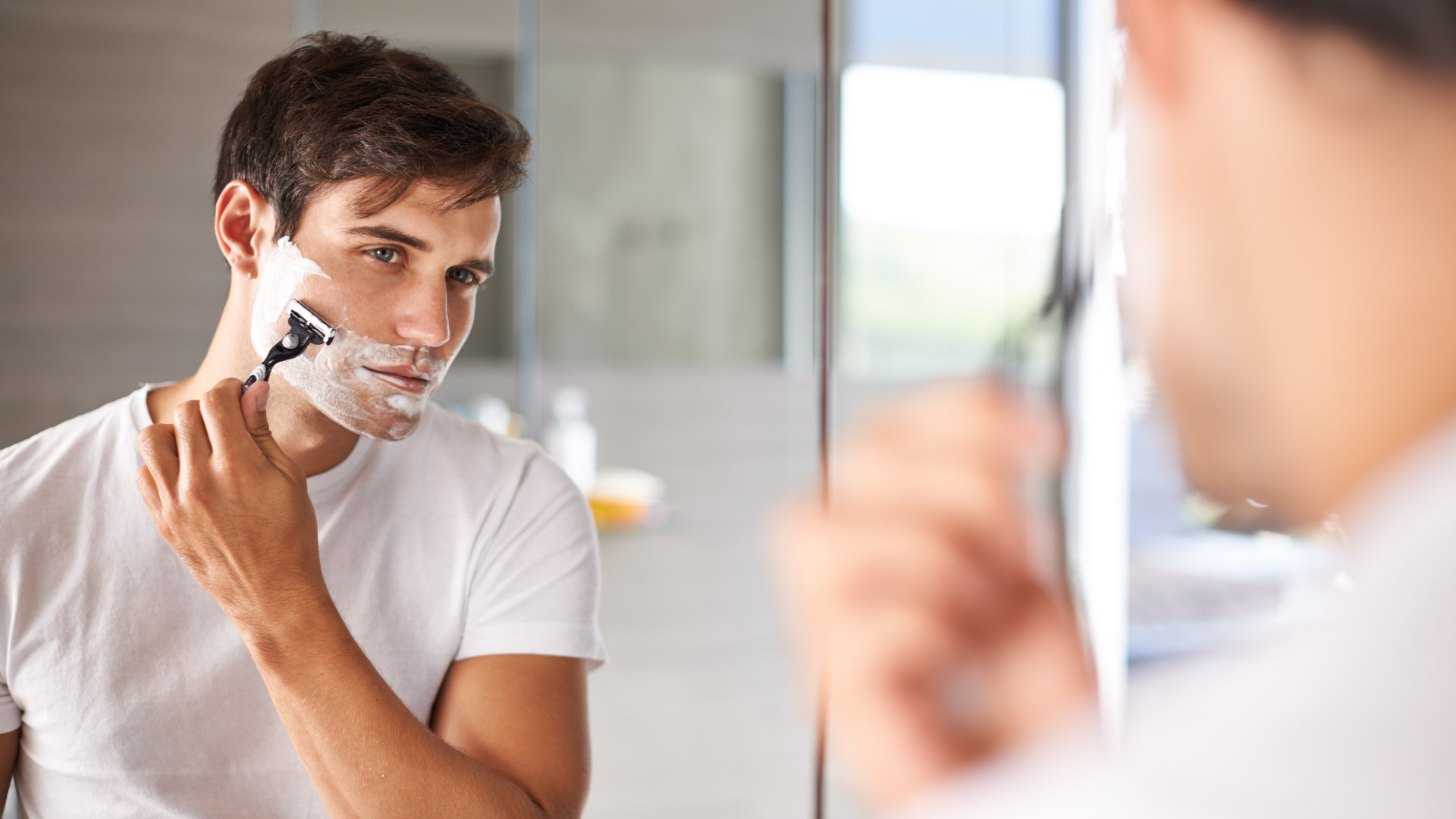 Man shaving in front of the mirror
