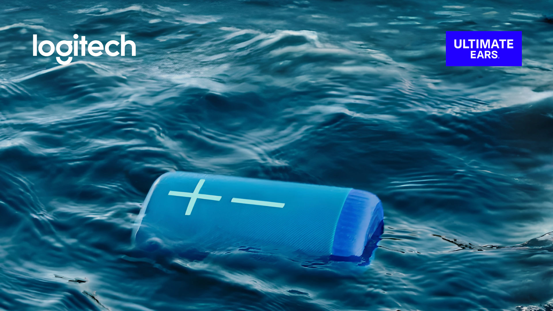 Blue Logitech portable speaker floating in ocean water, with the Logitech Ultimate Ears logo.