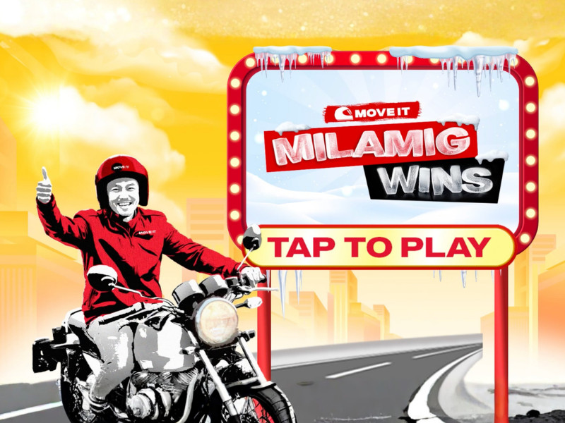 A man sitting on a motorcycle, next to a sign that says "MILAMIG WINS" and "TAP TO PLAY"