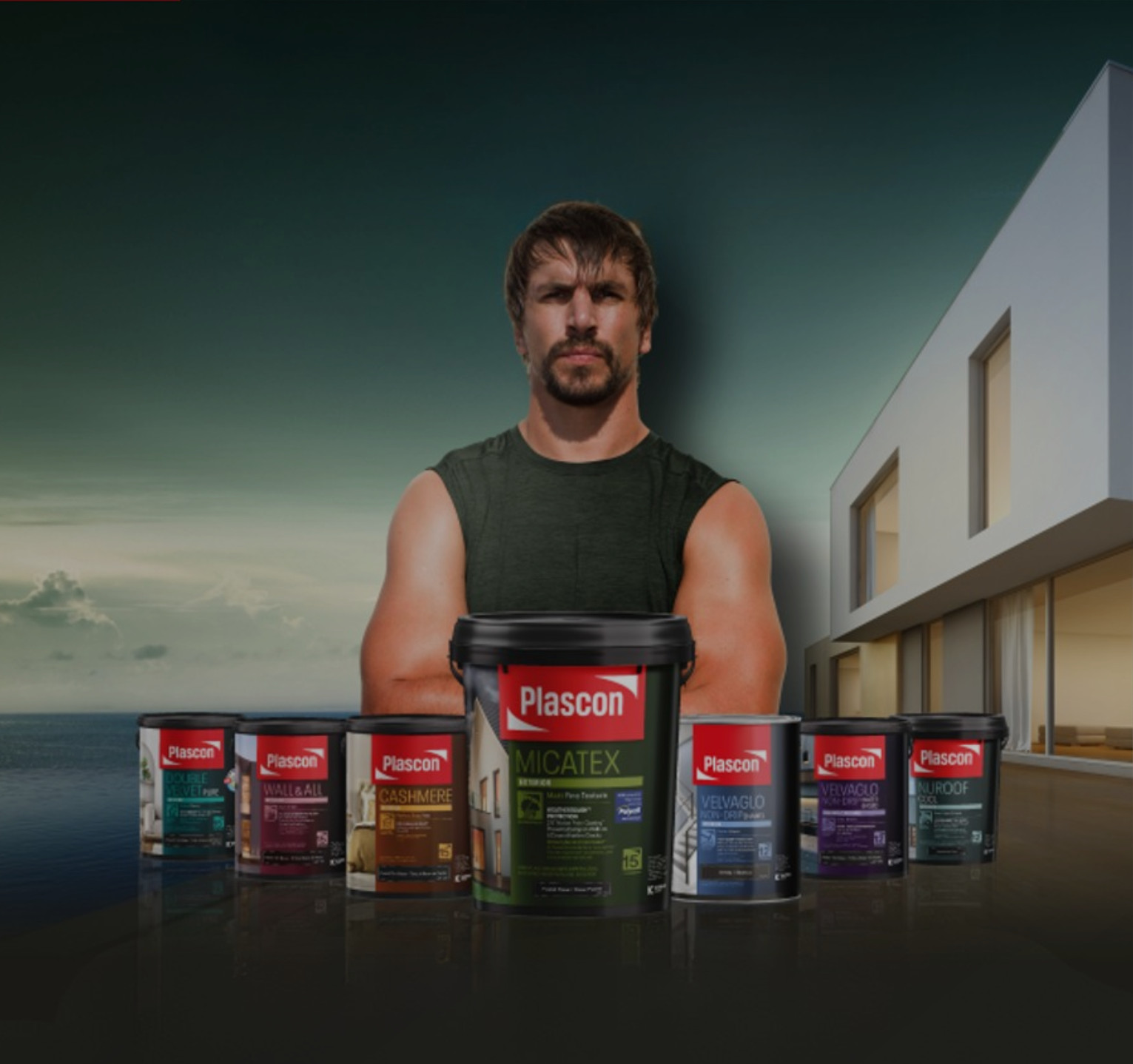 A muscular man wearing a sleeveless black shirt stands behind a row of Plascon paint cans