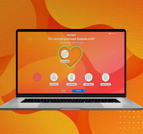 A laptop and a smartphone displaying a Fastweb promotional website with a yellow background and a gift box with snacks in front.