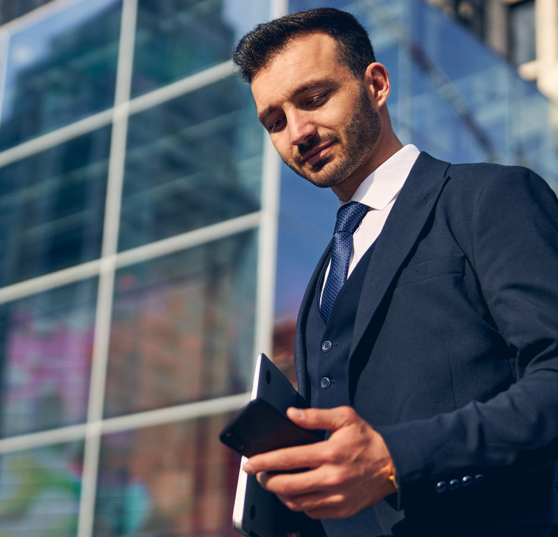 A man in a suit looking at his mobile phone