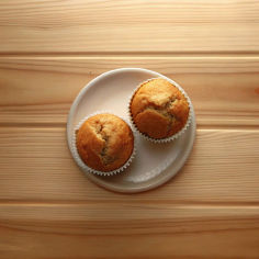 Two freshy baked banana cupcakes on a plate.