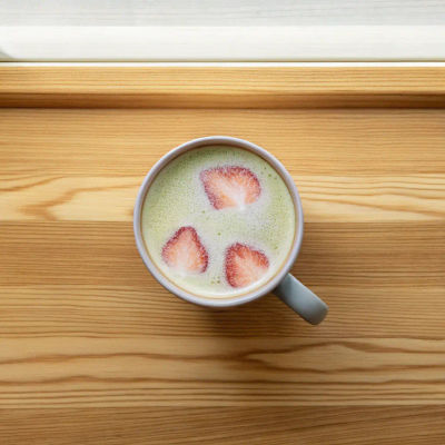 Layered strawberry matcha drink in cup.