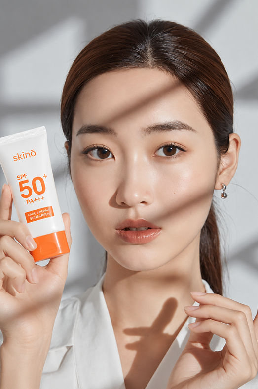 Woman holding skinO SPF 50 sunscreen product