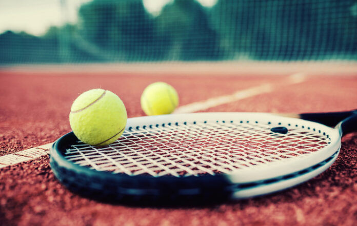 Tennis ball with racket on the tennis court. Sport, recreation concept