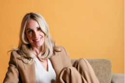 Atteline PR Dubai - Sophie posting while sitting in a couch with yellow background