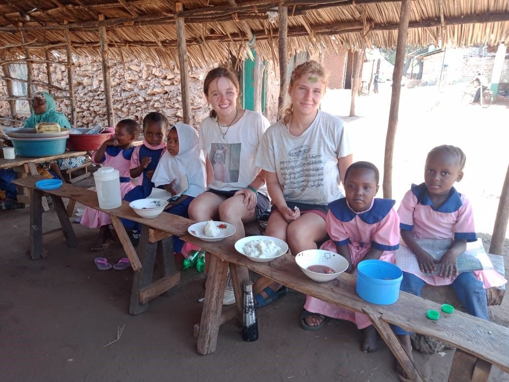 gap year volunteers have lunch with children in Kenya