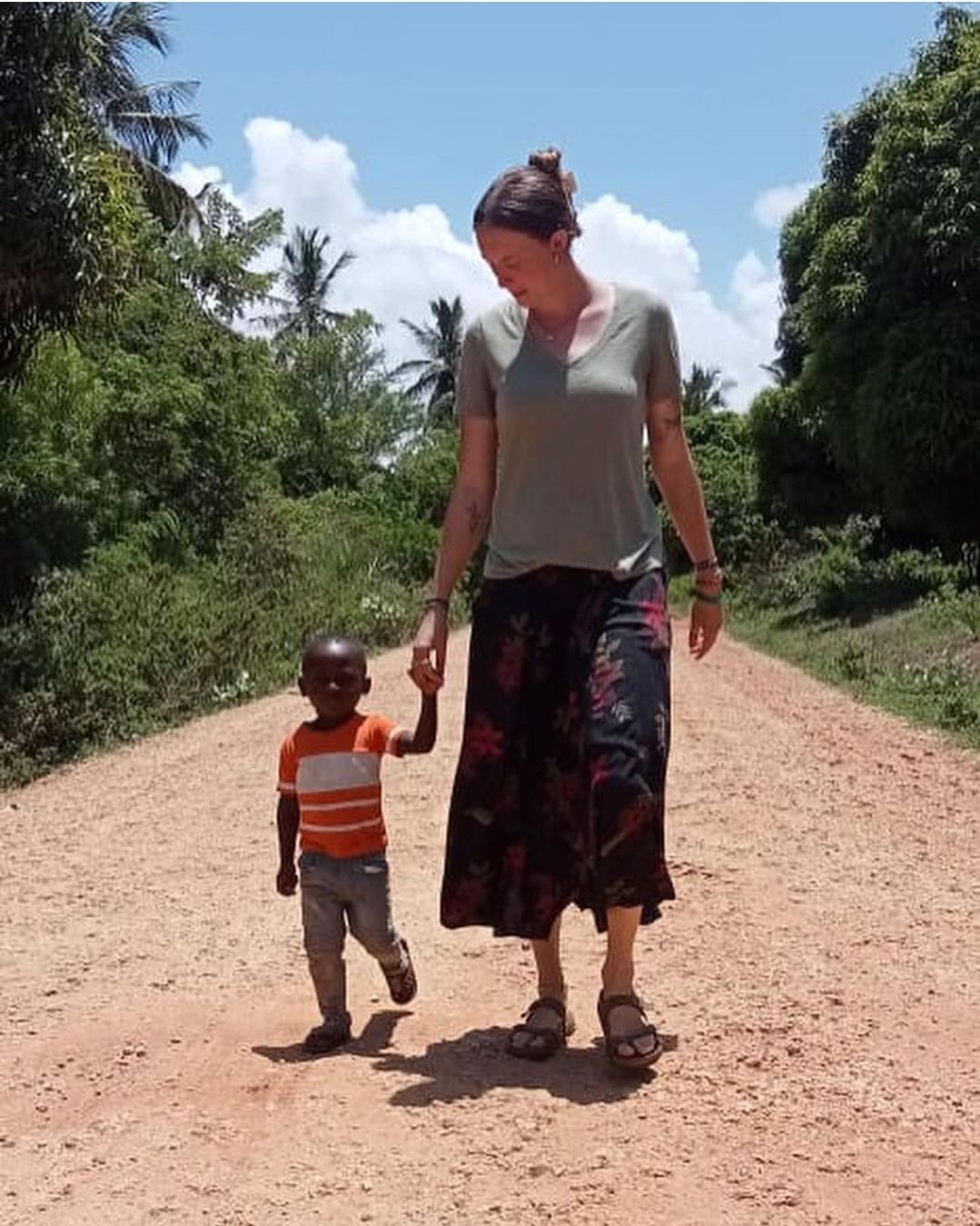 Gap Year volunteer holding a Kenyan child's hand