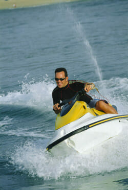 Man jet skiing and smiling (selective focus)