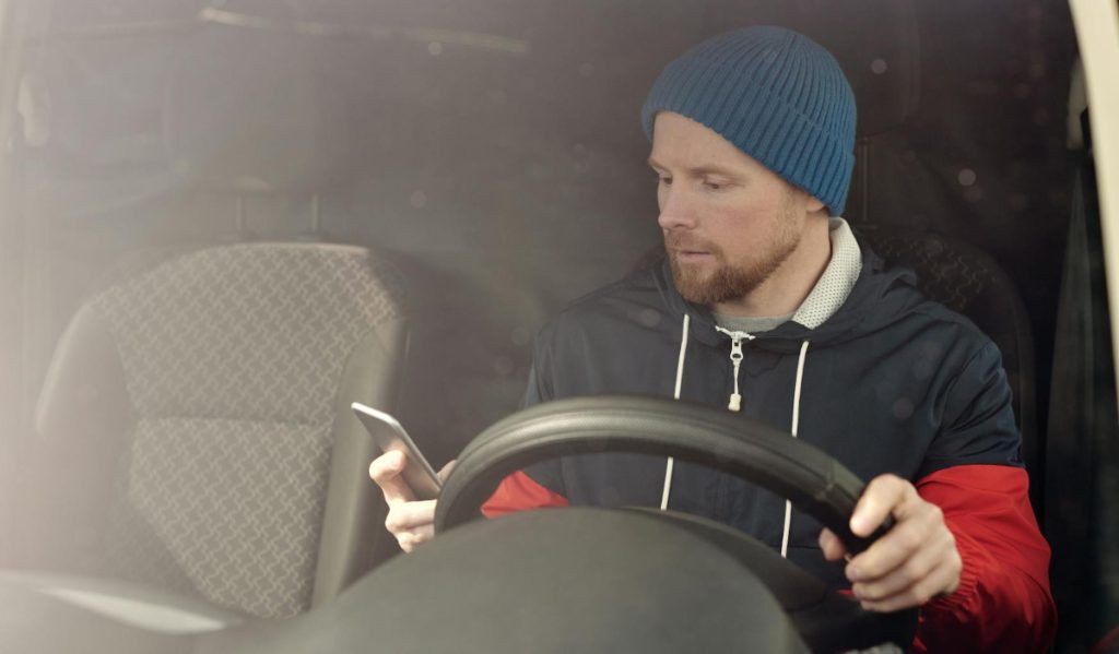 Distracted driver. Driver using his phone while driving.