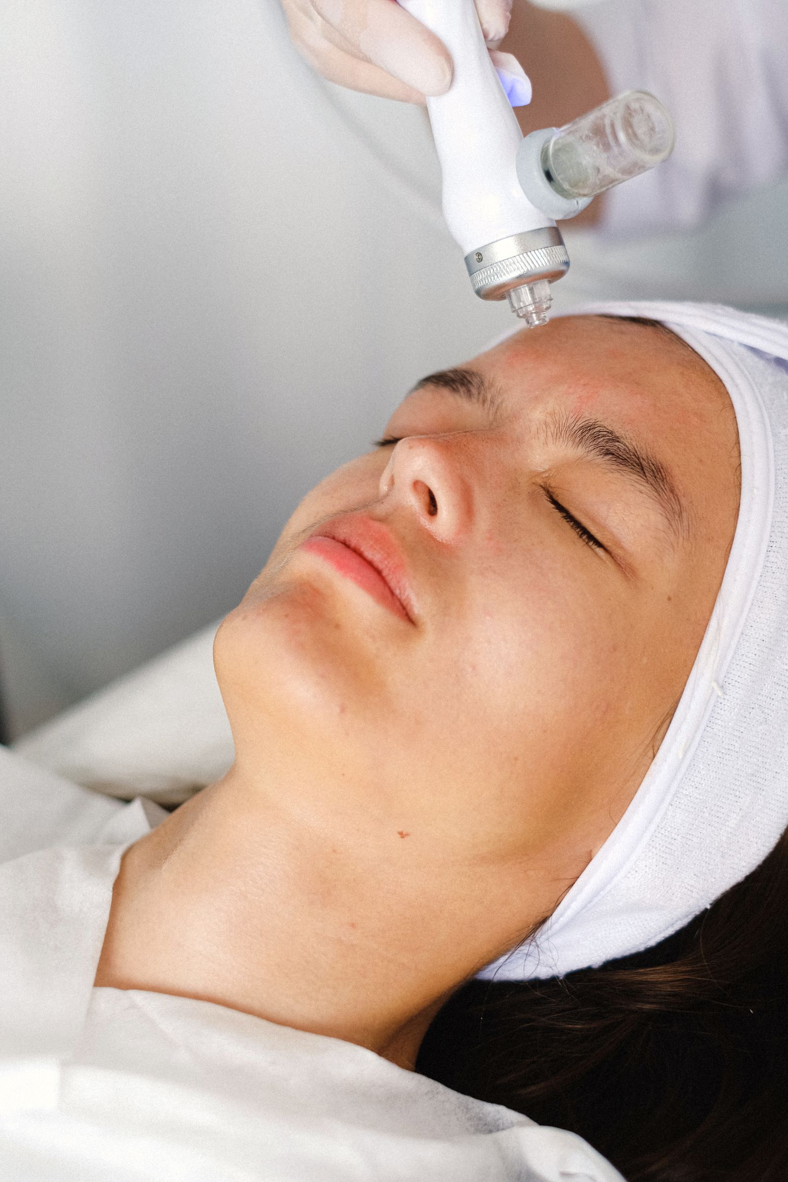 A skin treatment device passed over a client’s face in the clinic