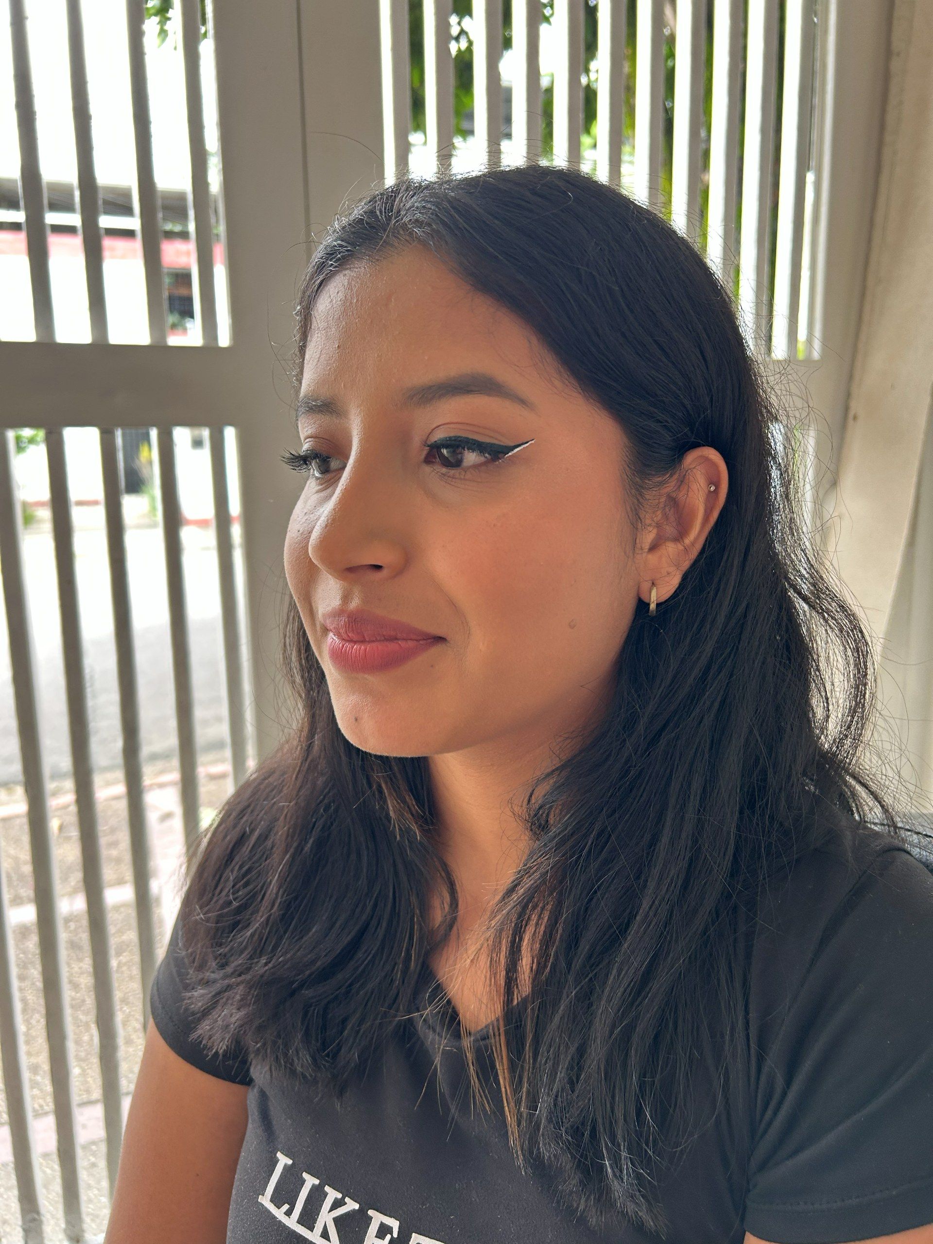 Maquillaje natural suave de lado, con delineado alado y labios nude