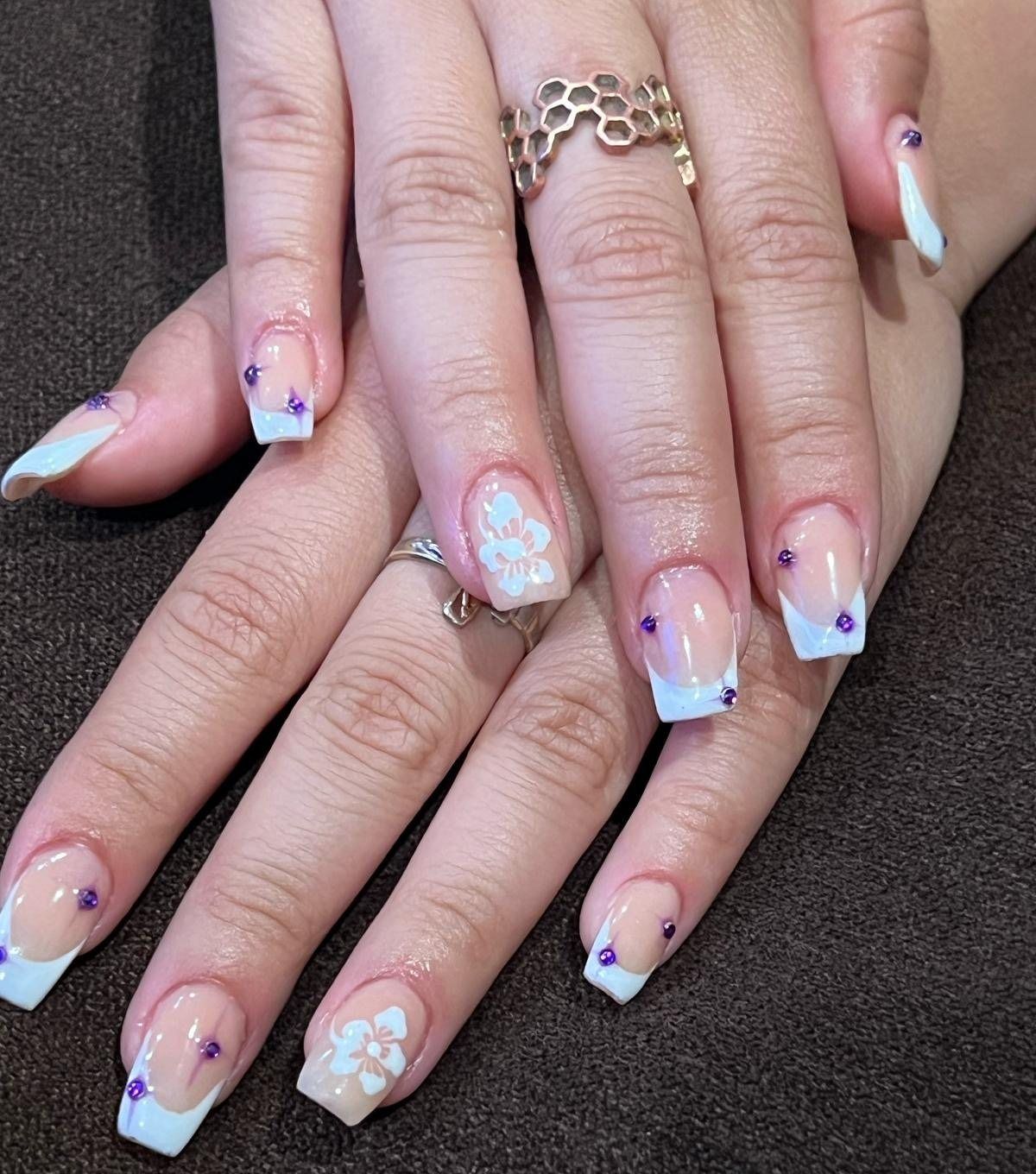 Uñas cuadradas largas con francesa azul claro, flores blancas pintadas a mano y cristales