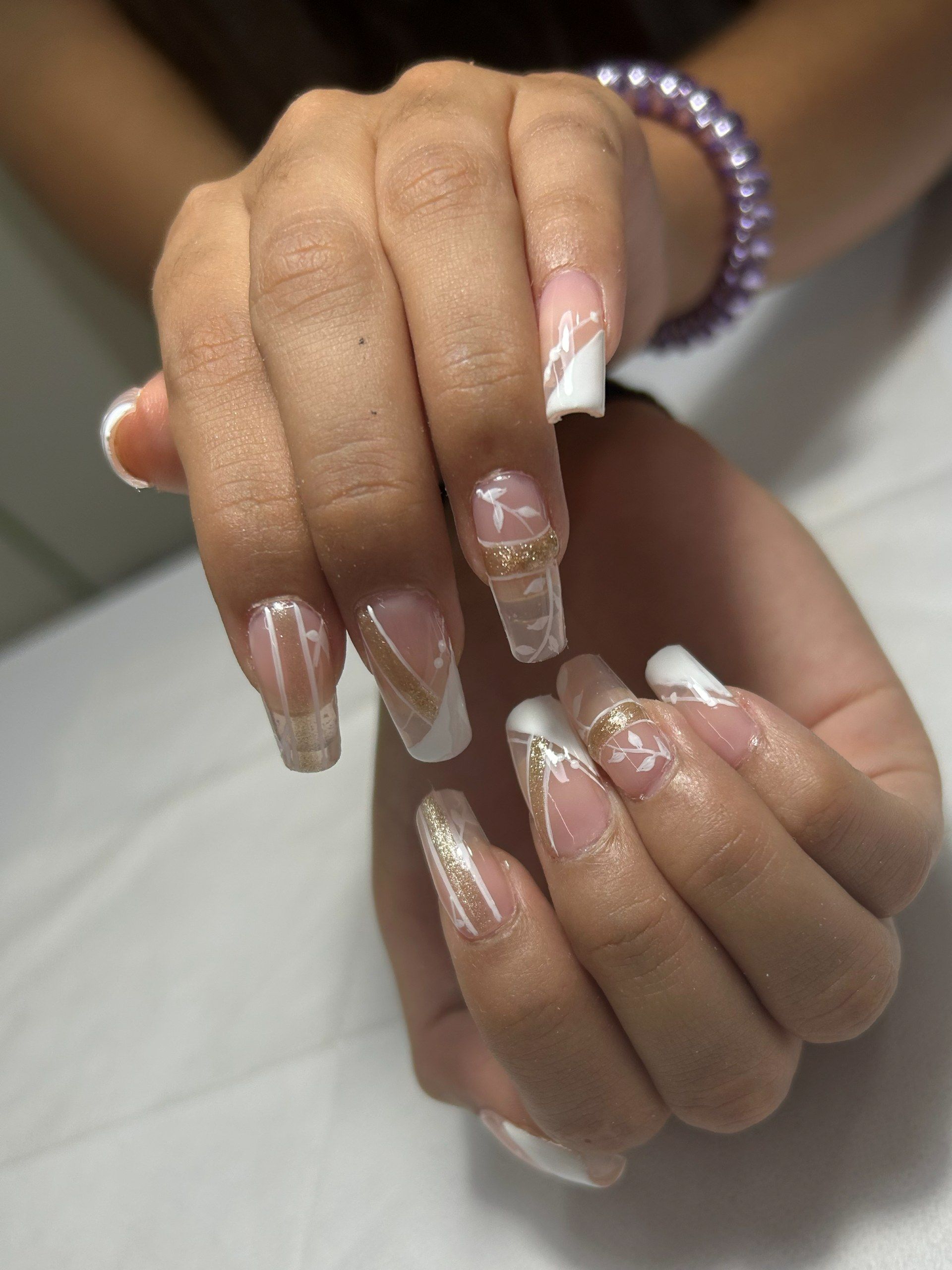 Uñas coffin largas transparentes con líneas blancas finas y detalles de remolinos dorados