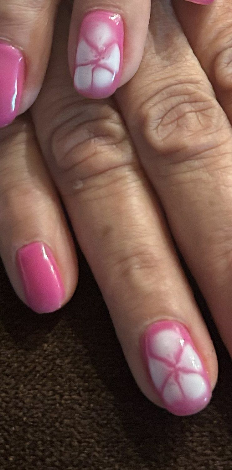 Uñas rosa intenso con flores blancas pequeñas pintadas a mano en dos dedos