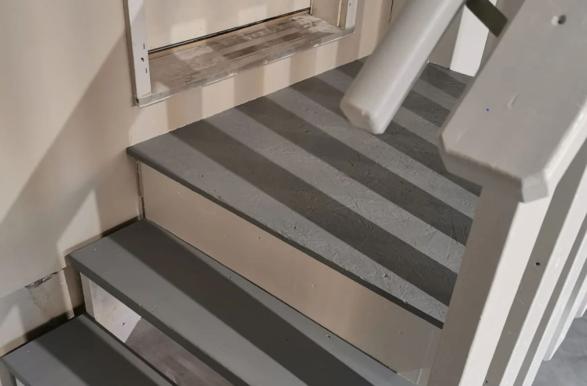 Painted garage steps, grey treads with cream risers and a white handrail