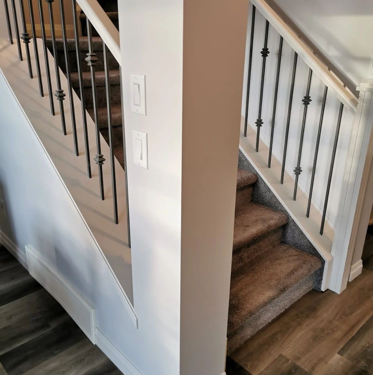 The same stairwell finished in warm beige with white trim and newel posts