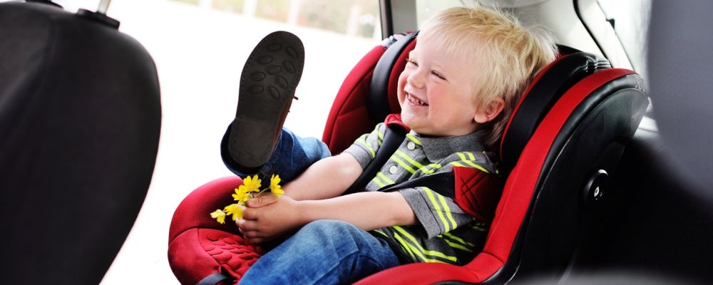 A boy on a baby seat inside a car