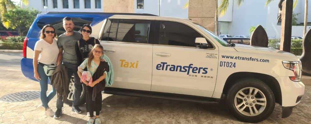 A family posses outside an eTransfers vehicle 