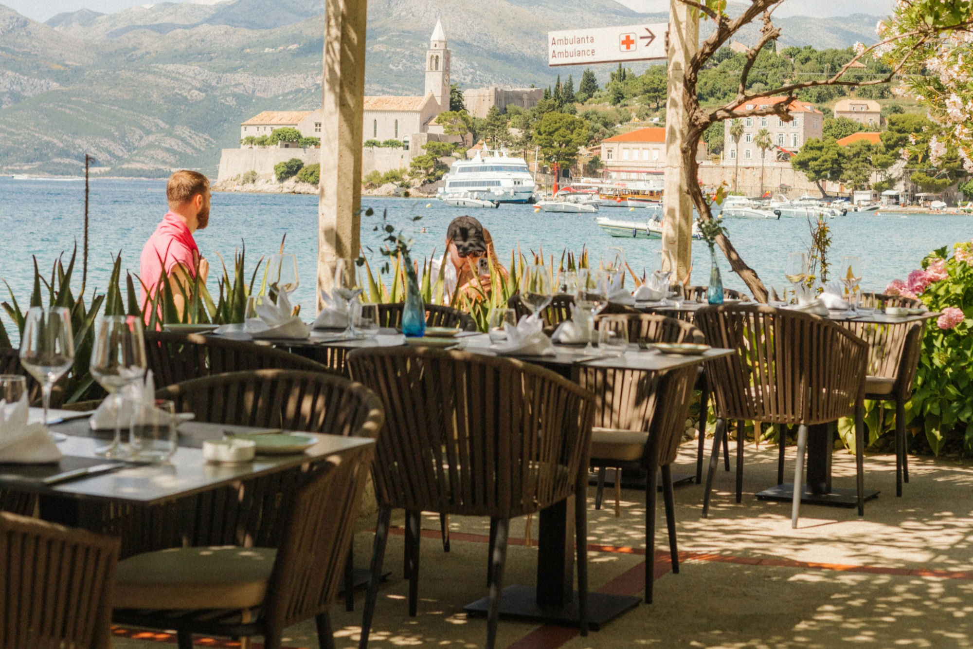 Ristorante affacciato sull'acqua a Dubrovnik, con tavoli e sedie, ideale per pasti a prezzi accessibili