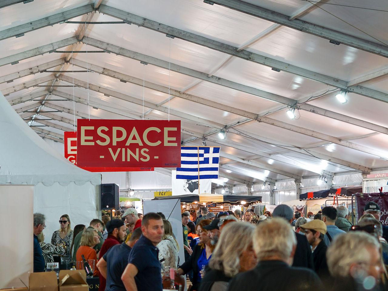 Visiteurs dégustant des vins et produits du terroir sous un chapiteau