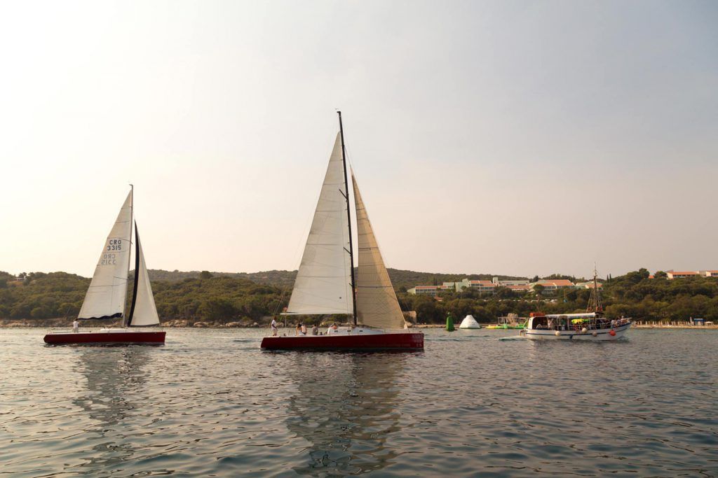 Red sailing boat in Romantic sunset sailing around Dubrovnik