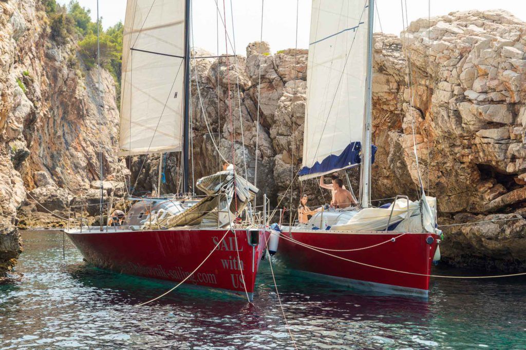 Two red sailboats in a cove