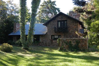 Fachada de casa rústica de piedra en bosque — proyecto Casa Cariló 1997, por Hugo Zawadski Arquitectos, en Cariló